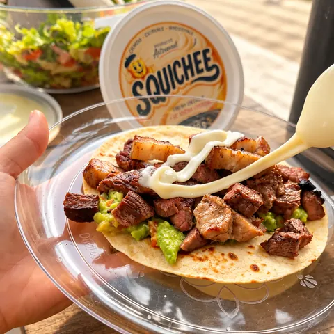 Crema Squichee servida con una cuchara sobre una comida para compartir.